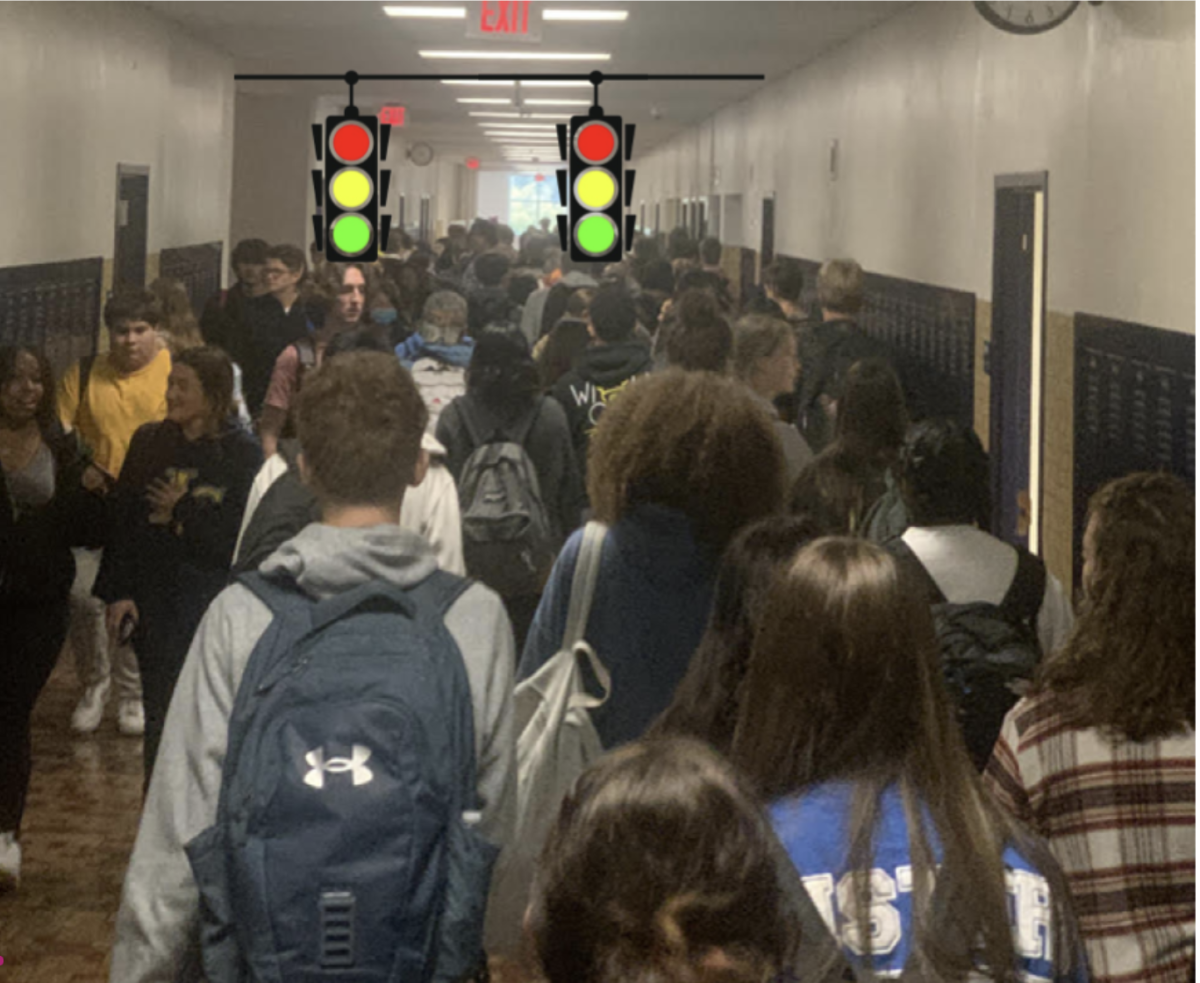 Students in a crowded hallway wait at a newly installed traffic light during a class change. Traffic lights were installed after a record number of hallwayway collisions last month, causing a variety of disturbances to the school environment.